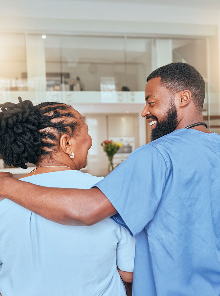 Male nurse with his arm around a patient and an encouraging smile